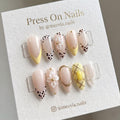 Almond-shaped yellow and leopard print press-on nail set with 3D white flowers and gold accents