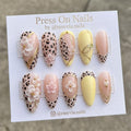 Long stiletto press-on nail set with white base, silver butterfly wing design, and iridescent opal shimmer.