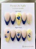 Almond-shaped blueberry press on nails with navy and yellow French tips and 3D fruit art