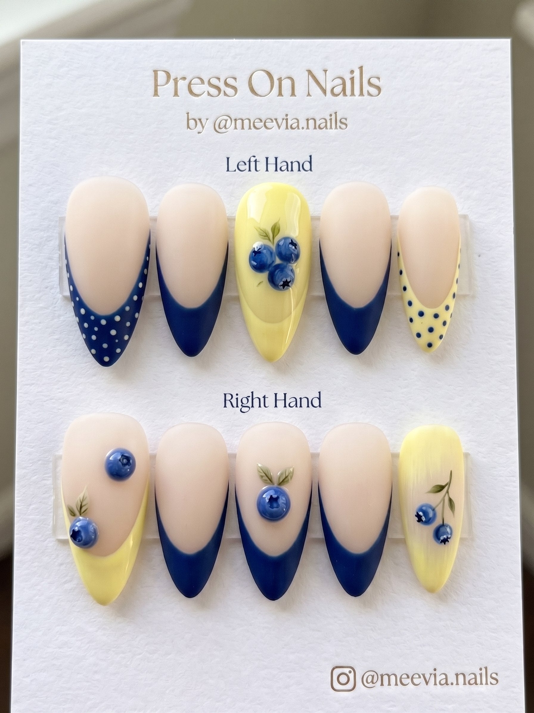 Almond-shaped blueberry press on nails with navy and yellow French tips and 3D fruit art