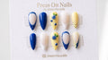 Almond-shaped press-on nail set featuring 3D blueberries, butter yellow base, and blue polka dots.