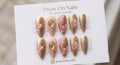 Stiletto-shaped gold and nude press on nails with 3D pink flowers and vintage pearl cameo details