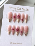 Stiletto-shaped floral French tip press-on nails with pink base and polka dot details