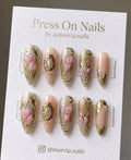 Almond-shaped nude press on nails with 3D pink hearts and gold filigree accents