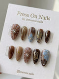 Almond-shaped brown and blue press-on nail set with 3D floral textures and gold art