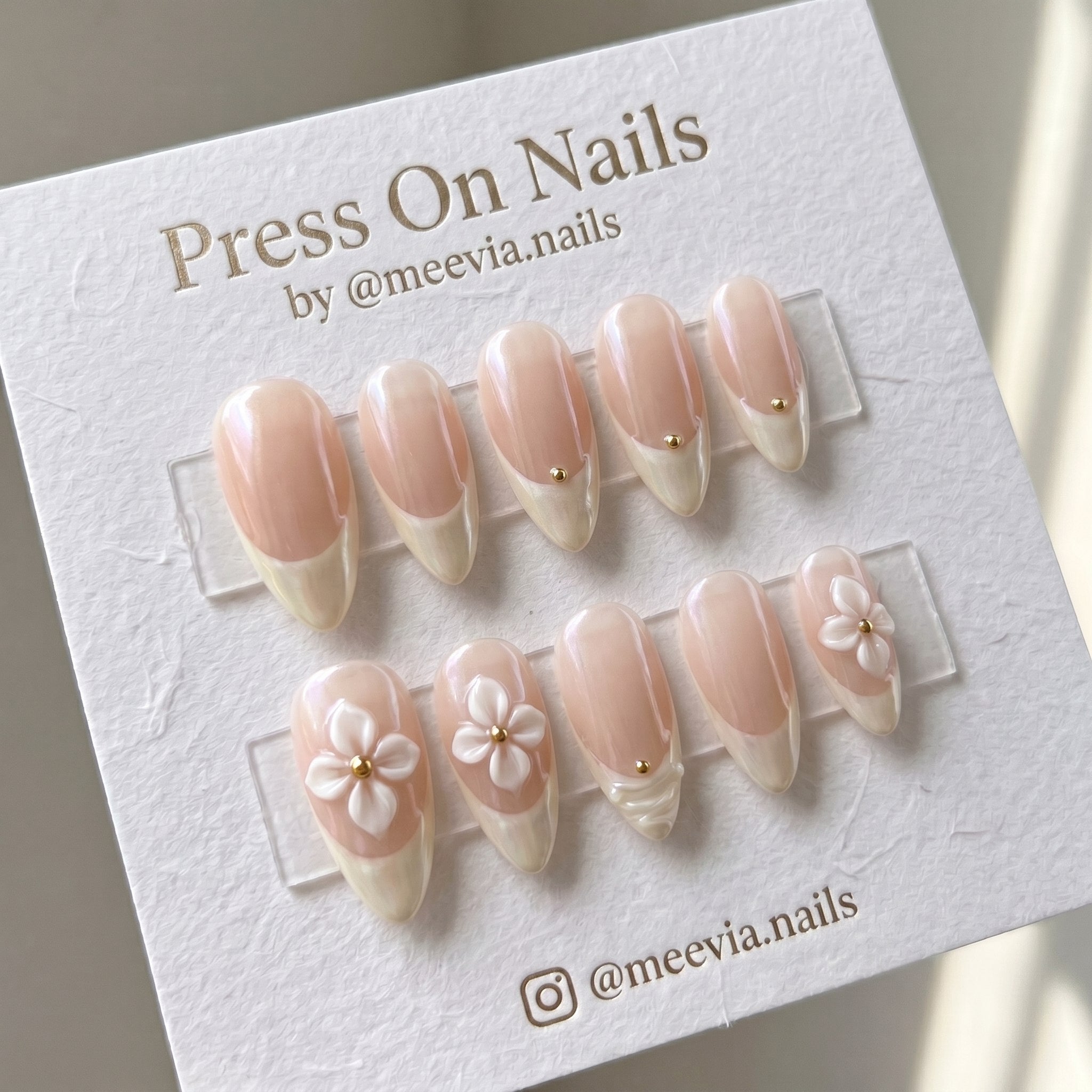 Almond-shaped shimmer French tip press-on nail set with 3D white flowers and gold accents