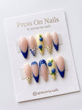Stiletto-shaped press-on nails with blue French tips and blueberry 3D nail art.