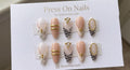 Almond-shaped zebra print press-on nails with gold accents and 3D nail art