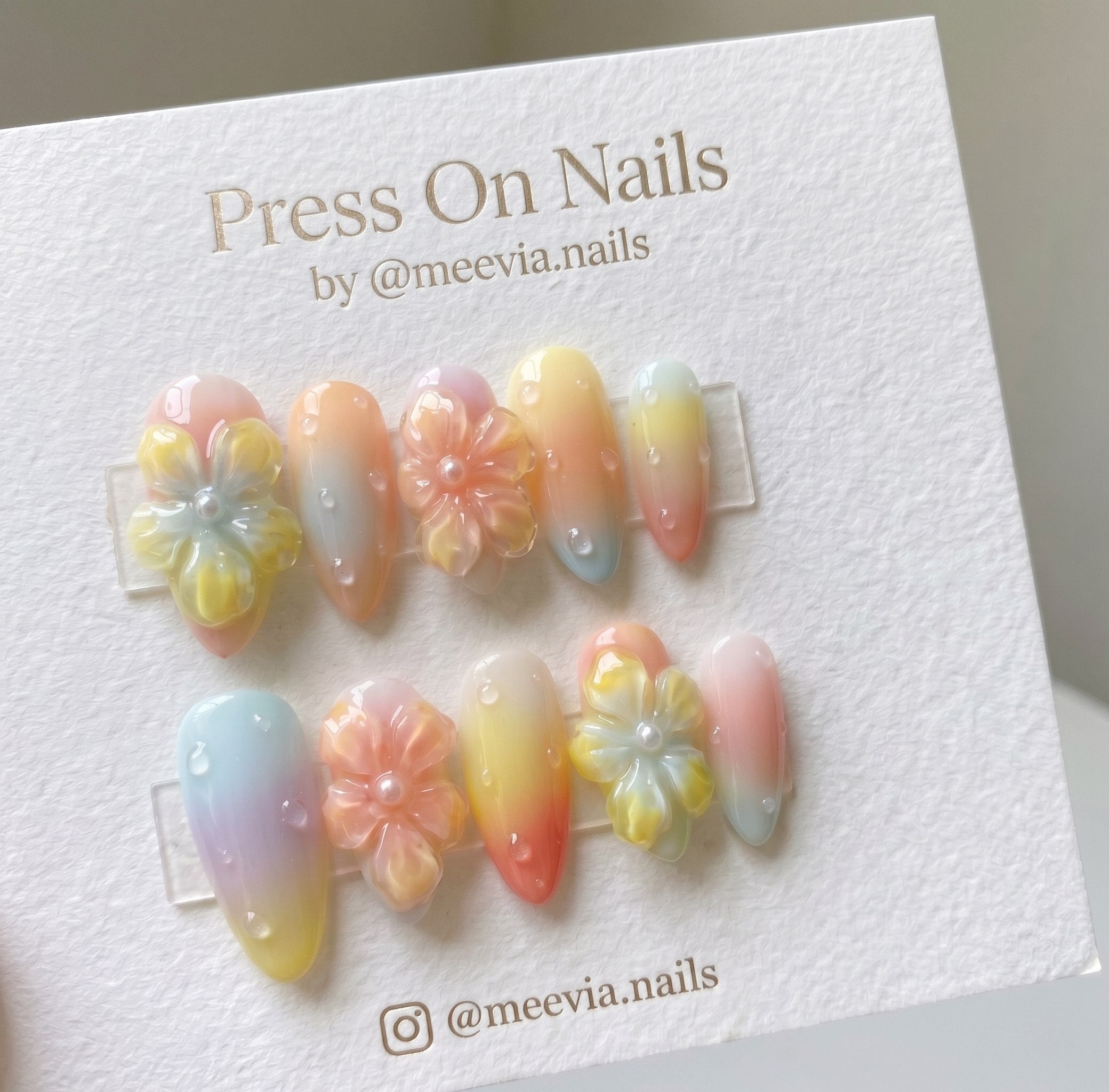 Almond-shaped pastel gradient press-on nails with 3D floral art and dewdrop details