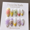 Almond-shaped press-on nail set with 3D ocean shells, starfish, and floral motifs in pastel colors.