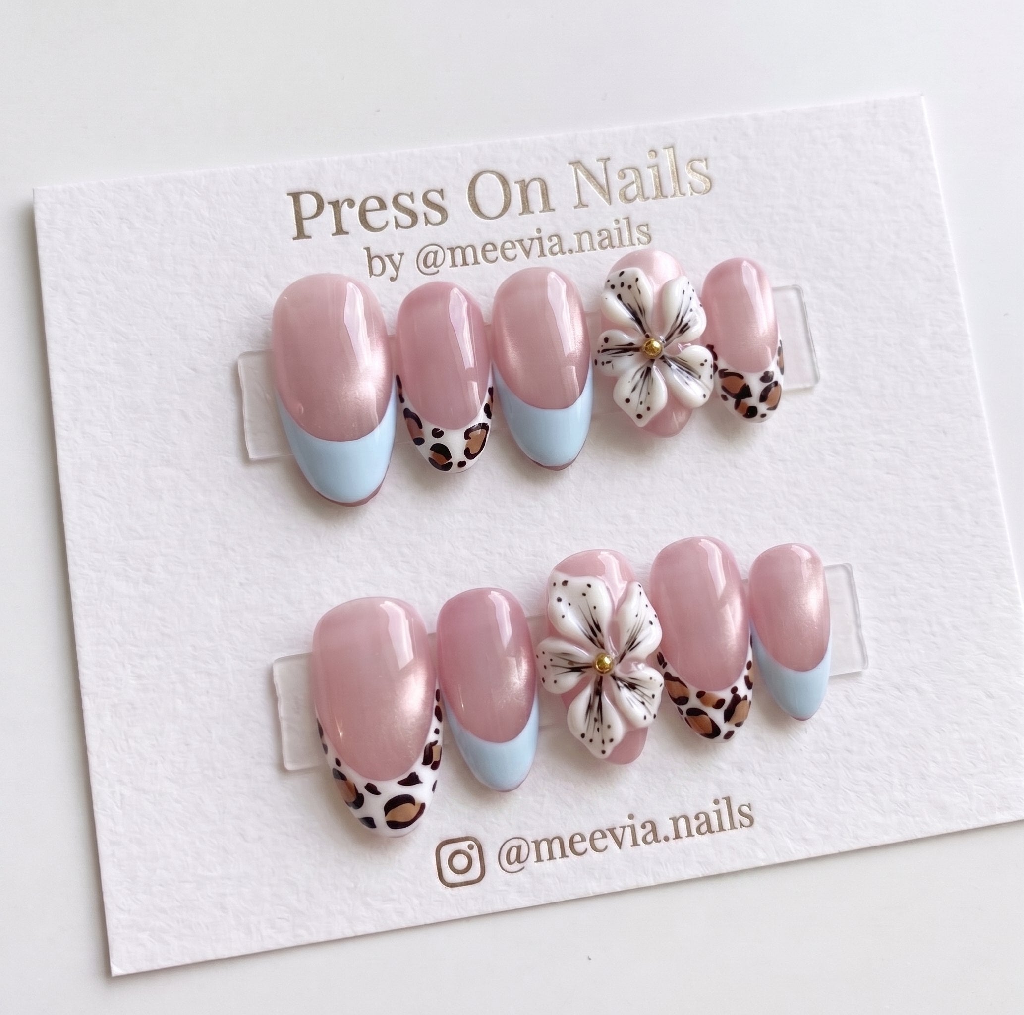 Almond-shaped press-on nails with French tips, leopard print accents, and 3D floral nail art.