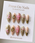 Almond-shaped floral press-on nails with gold leaf and pearl accents