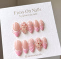 Almond-shaped pink French tip press-on nail set with 3D floral and shell art