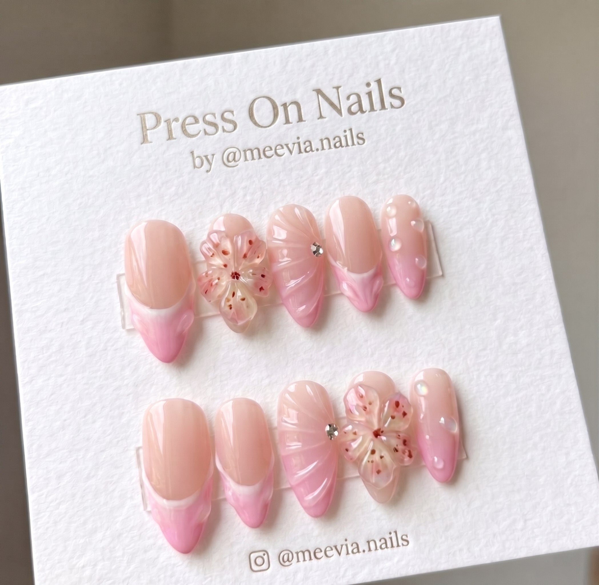 Almond-shaped pink French tip press-on nail set with 3D floral and shell art