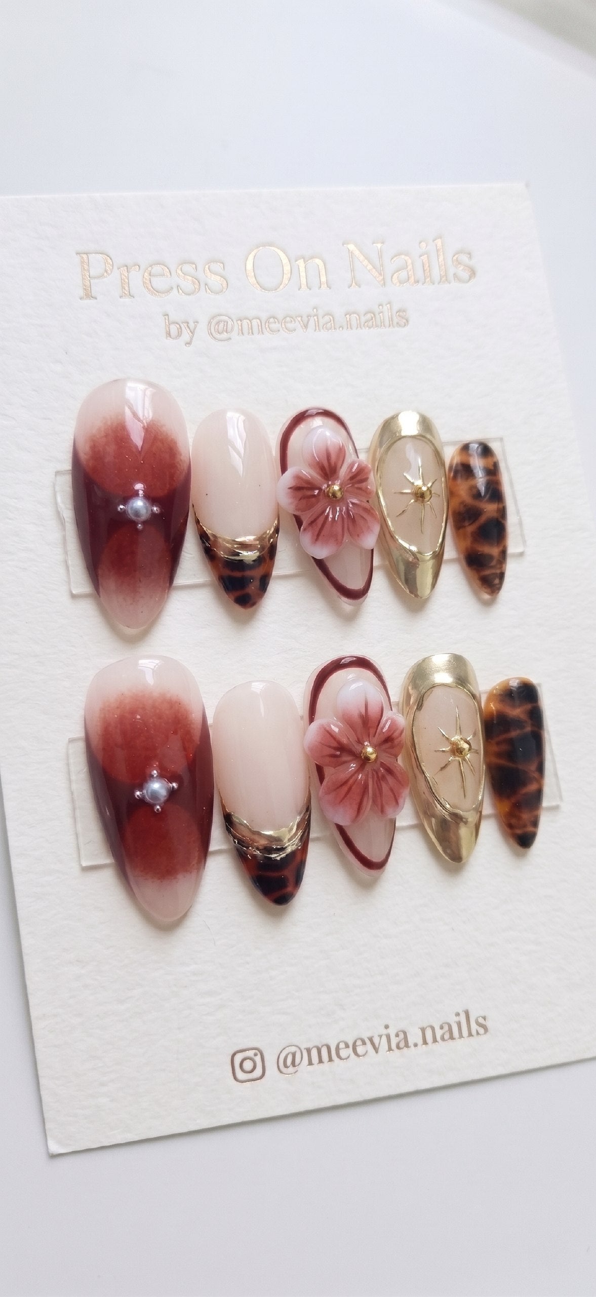 Almond-shaped burgundy and gold press-on nail set with 3D floral art and tortoiseshell patterns
