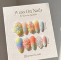 Almond-shaped pastel press-on nails with 3D floral art and delicate embellishments