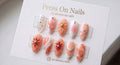 Almond-shaped peach and white 3D floral press-on nail set with gold studs