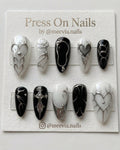 Stiletto-shaped black and white press-on nail set with 3D silver chrome heart and gothic motifs