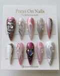 Stiletto-shaped pink chrome press-on nail set with 3d silver molten metal art and iridescent heart centerpiece