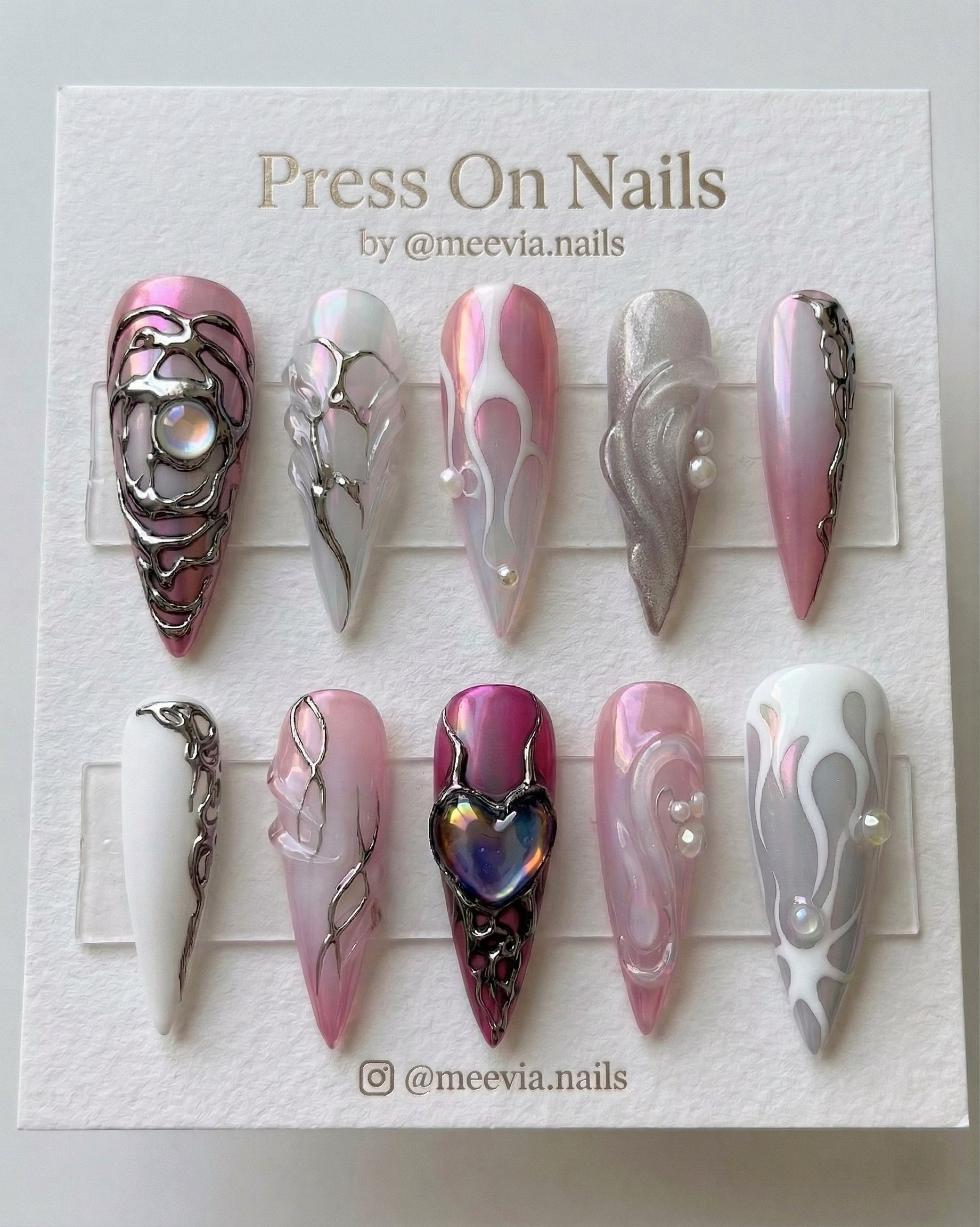 Stiletto-shaped pink chrome press-on nail set with 3d silver molten metal art and iridescent heart centerpiece