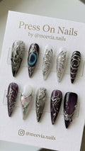 Long stiletto press on nails with purple jelly base, 3D silver chrome swirls, and iridescent butterfly wing motifs.