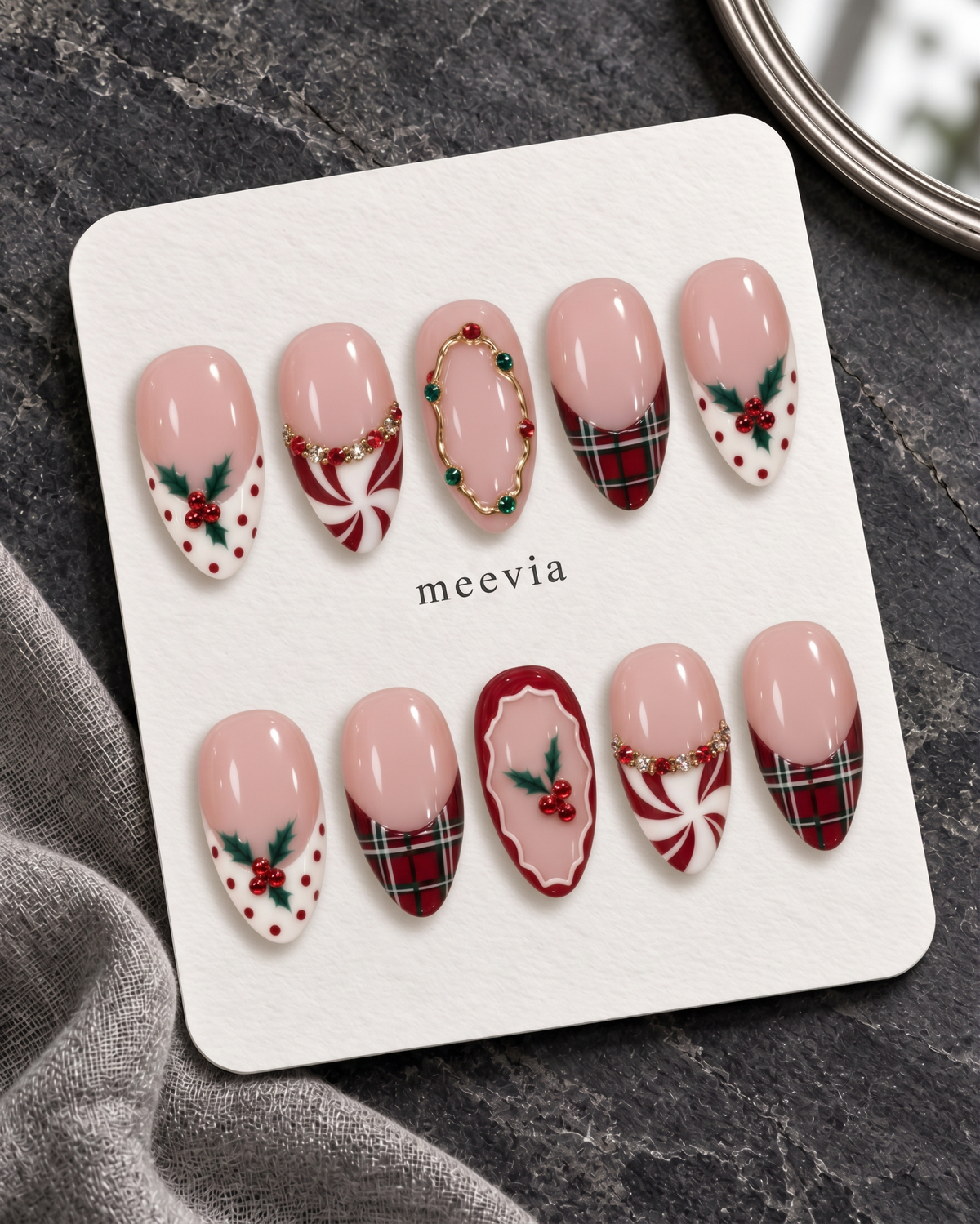 Pink Christmas press-on nails with plaid tips, holly berries, peppermint swirls, and glossy finish