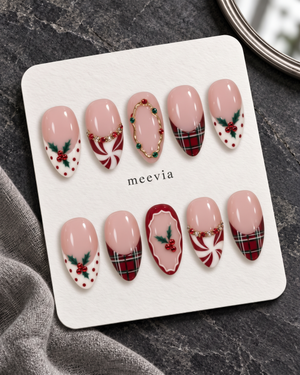 Pink Christmas press-on nails with plaid tips, holly berries, peppermint swirls, and glossy finish