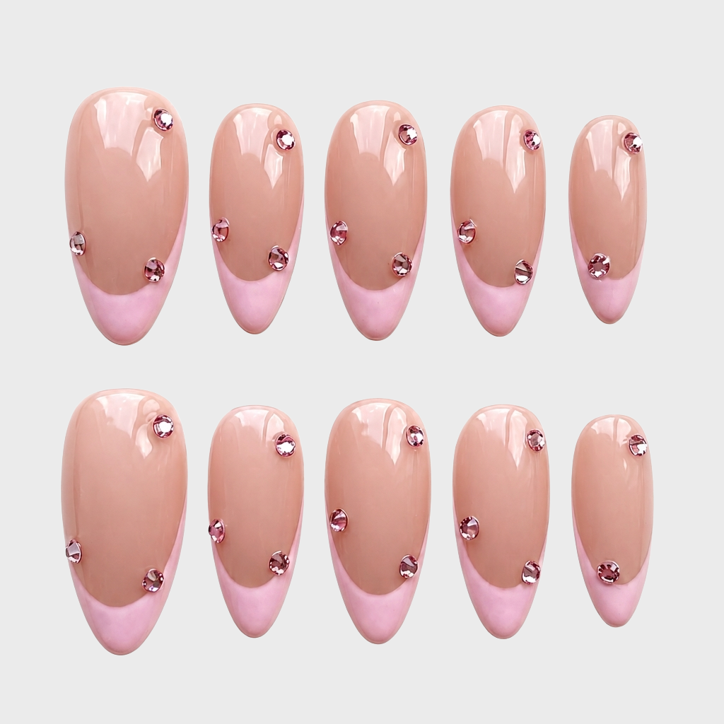 Pink French tip press-on nails decorated with small pink rhinestones.