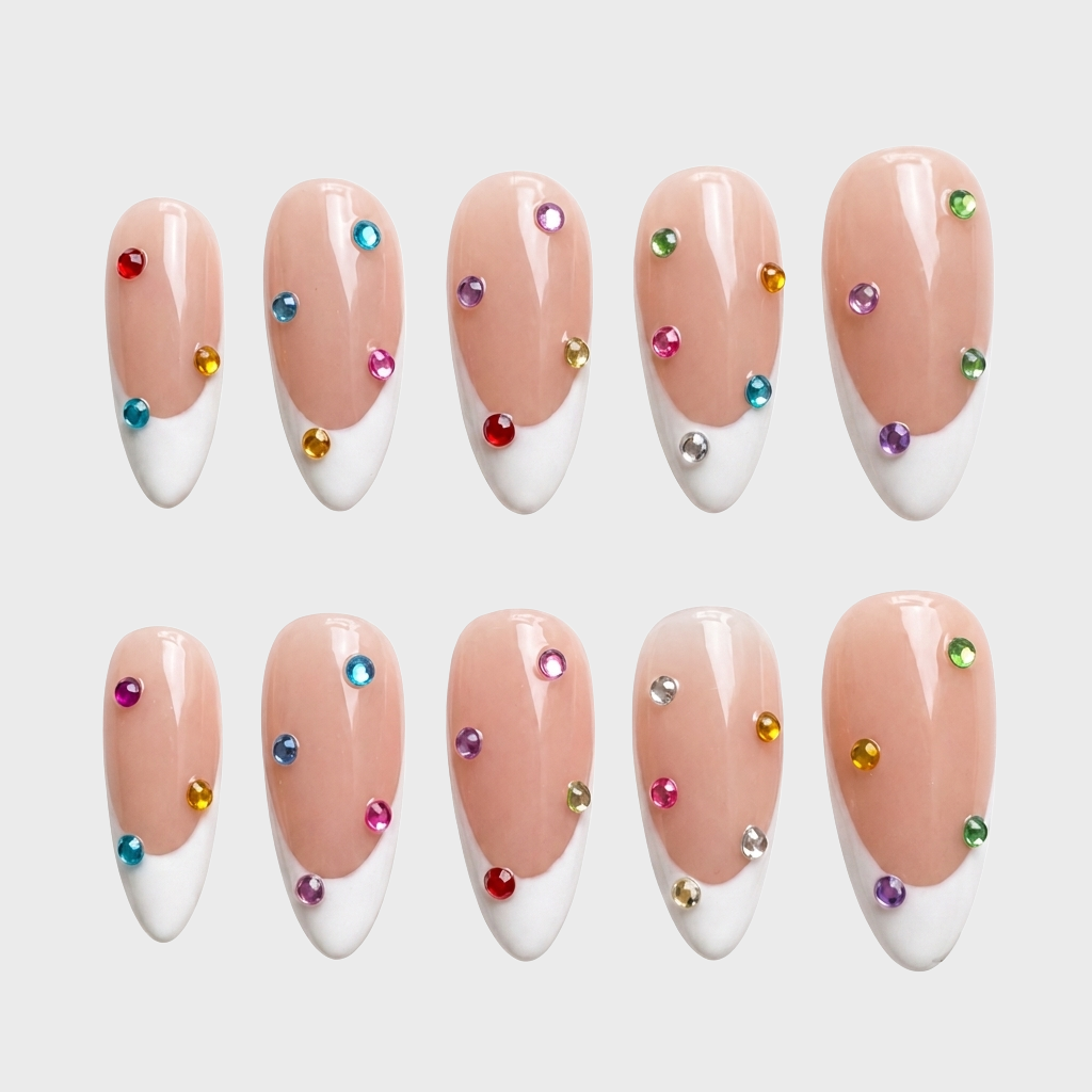 Almond shaped press-on nails with white French tips and scattered colorful round gems.