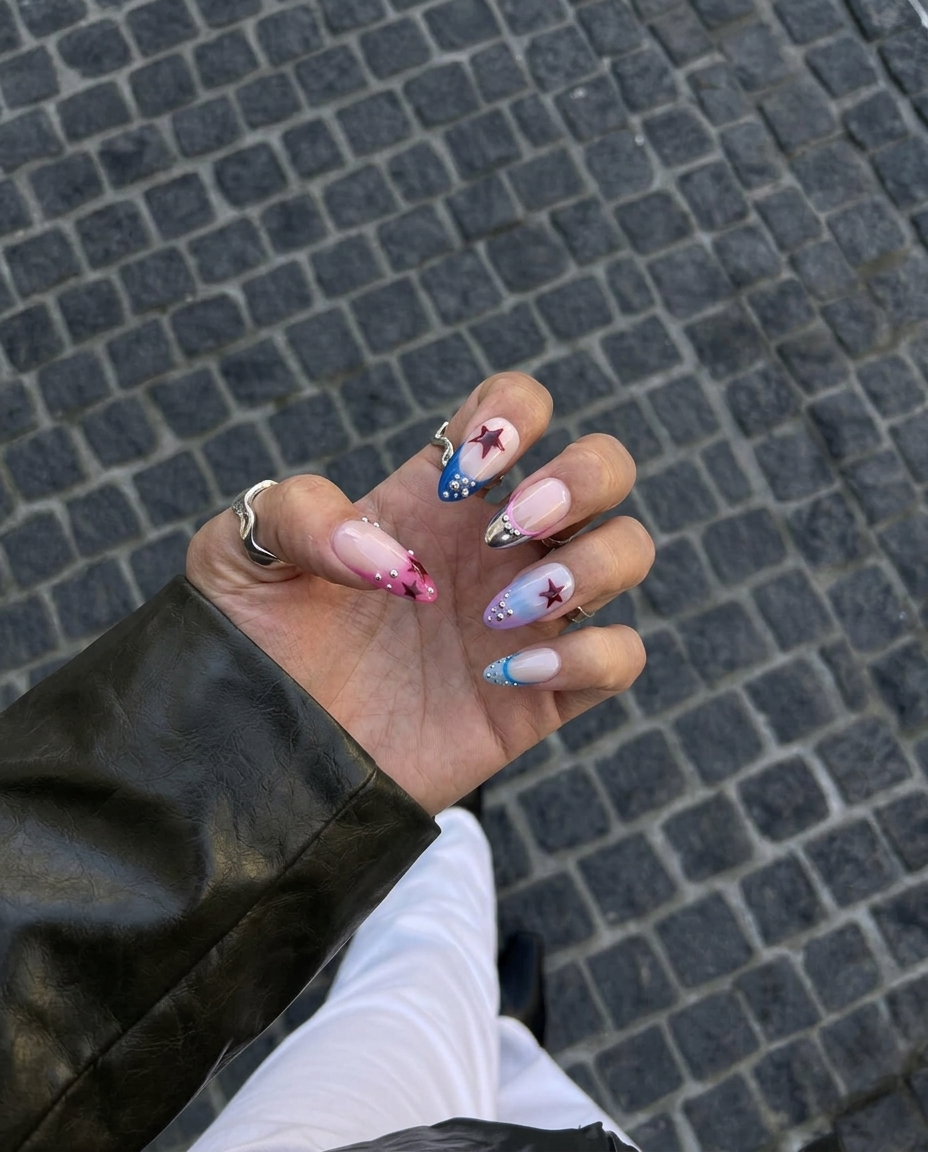 A set of press-on nails featuring a French tip design with red star accents and silver beads on a nude base.