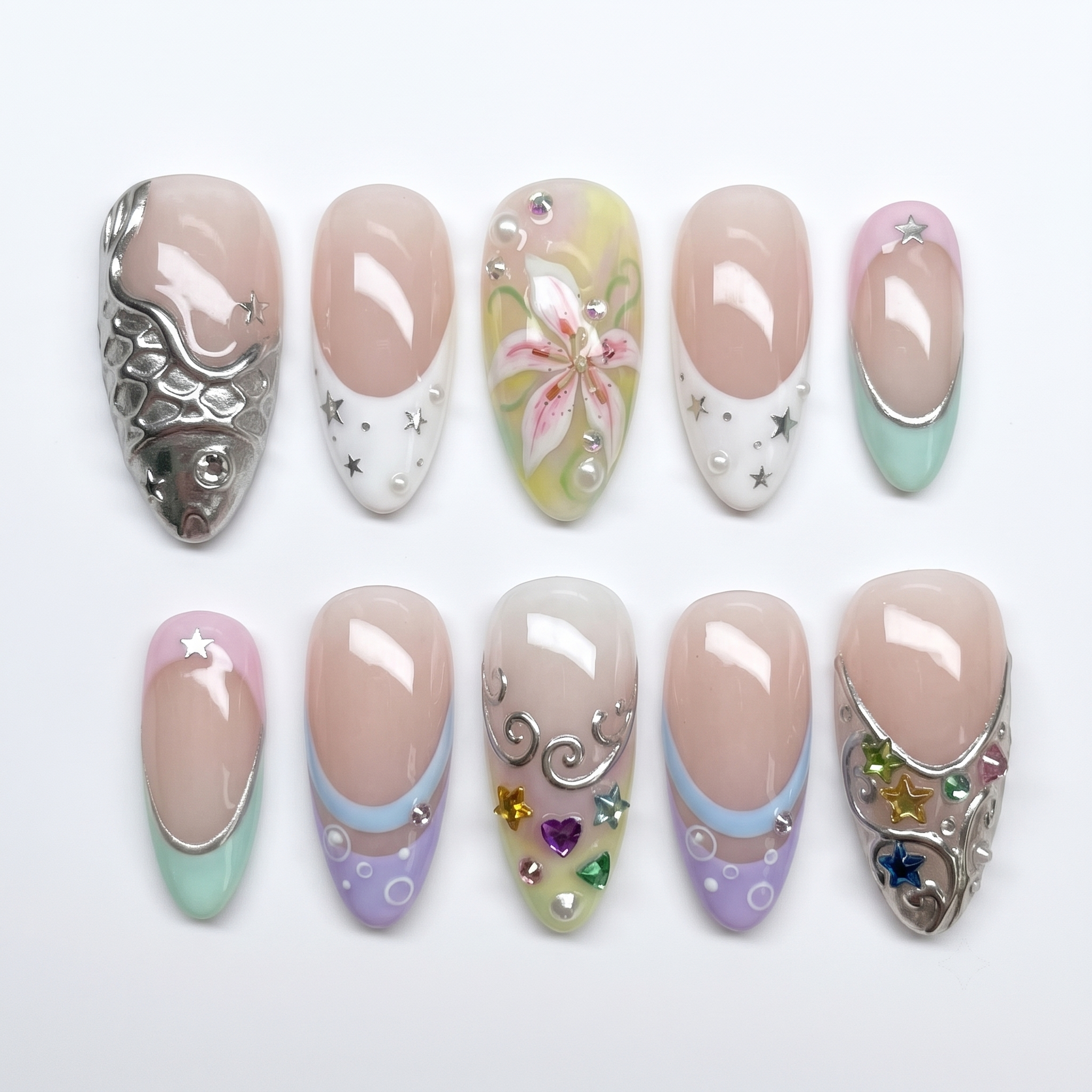 Pastel mermaid press-on nails featuring silver metallic fish scales, colorful star gems, and a pink lily flower design.