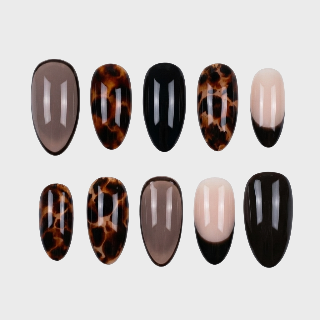 A collection of press-on nails featuring tortoise shell patterns, solid black, and sheer neutral tips.
