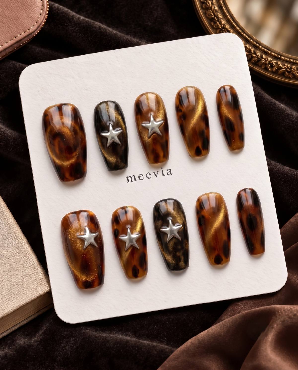 Tortoise-shell cat-eye press-on nails with raised silver star embellishments