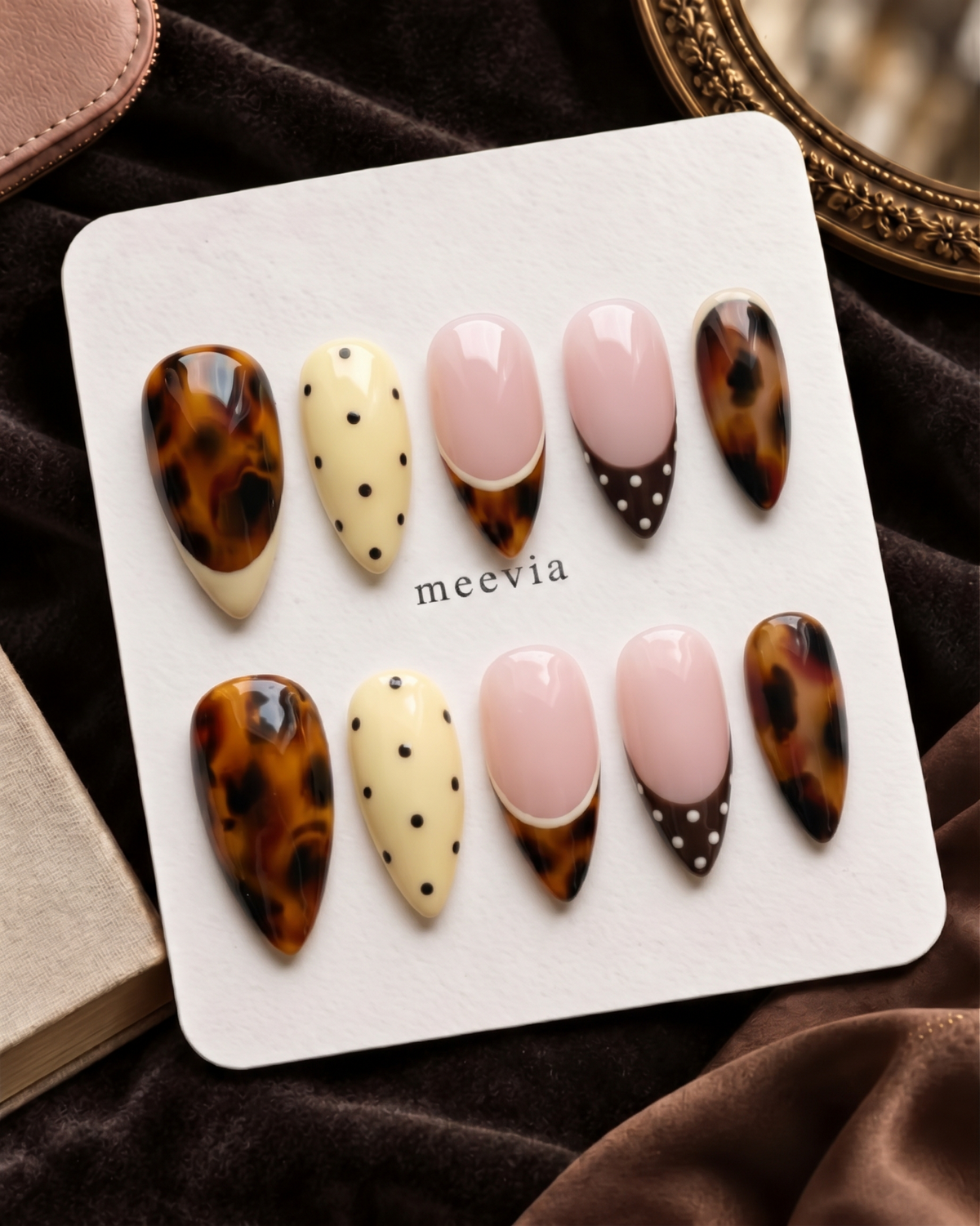 Tortoiseshell, pink French, and yellow polka dot press-on nails displayed on a white card