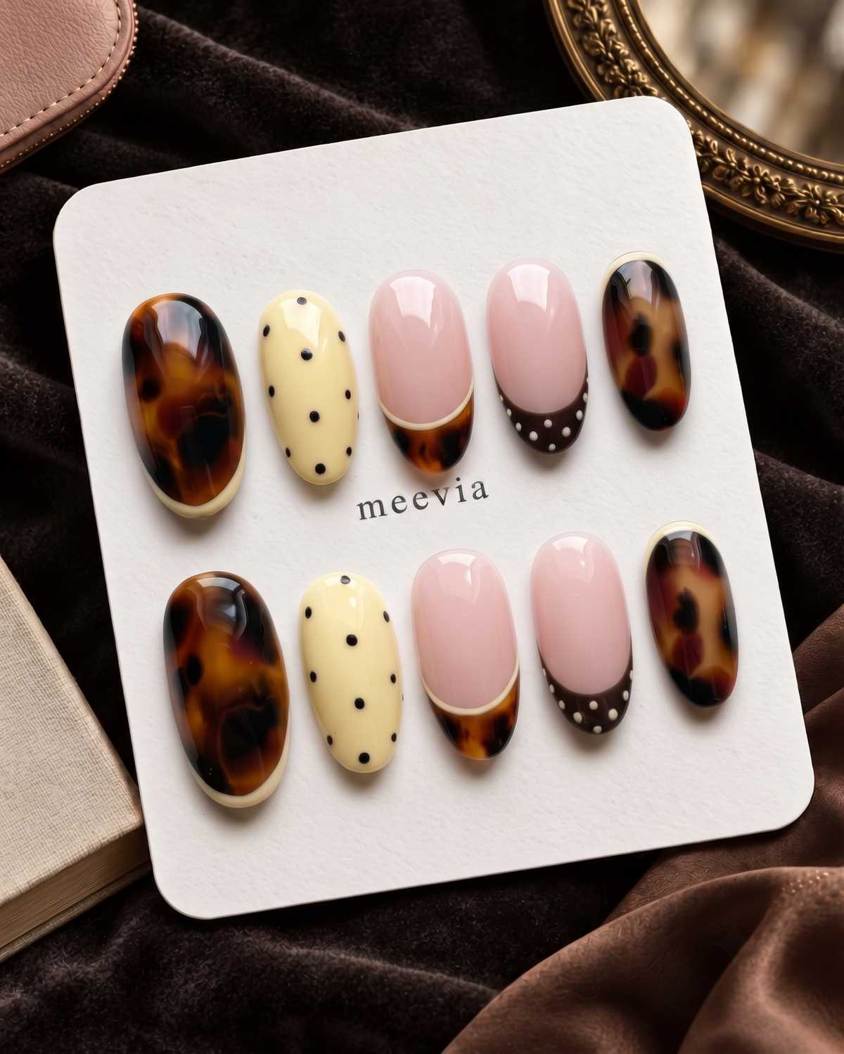 Tortoiseshell, pink French, and yellow polka dot press-on nails displayed on a white card