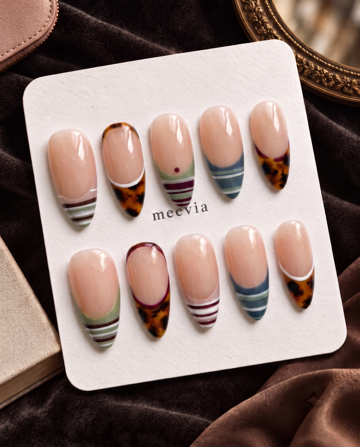 Nude press-on nails with tortoiseshell French tips and multicolor striped designs