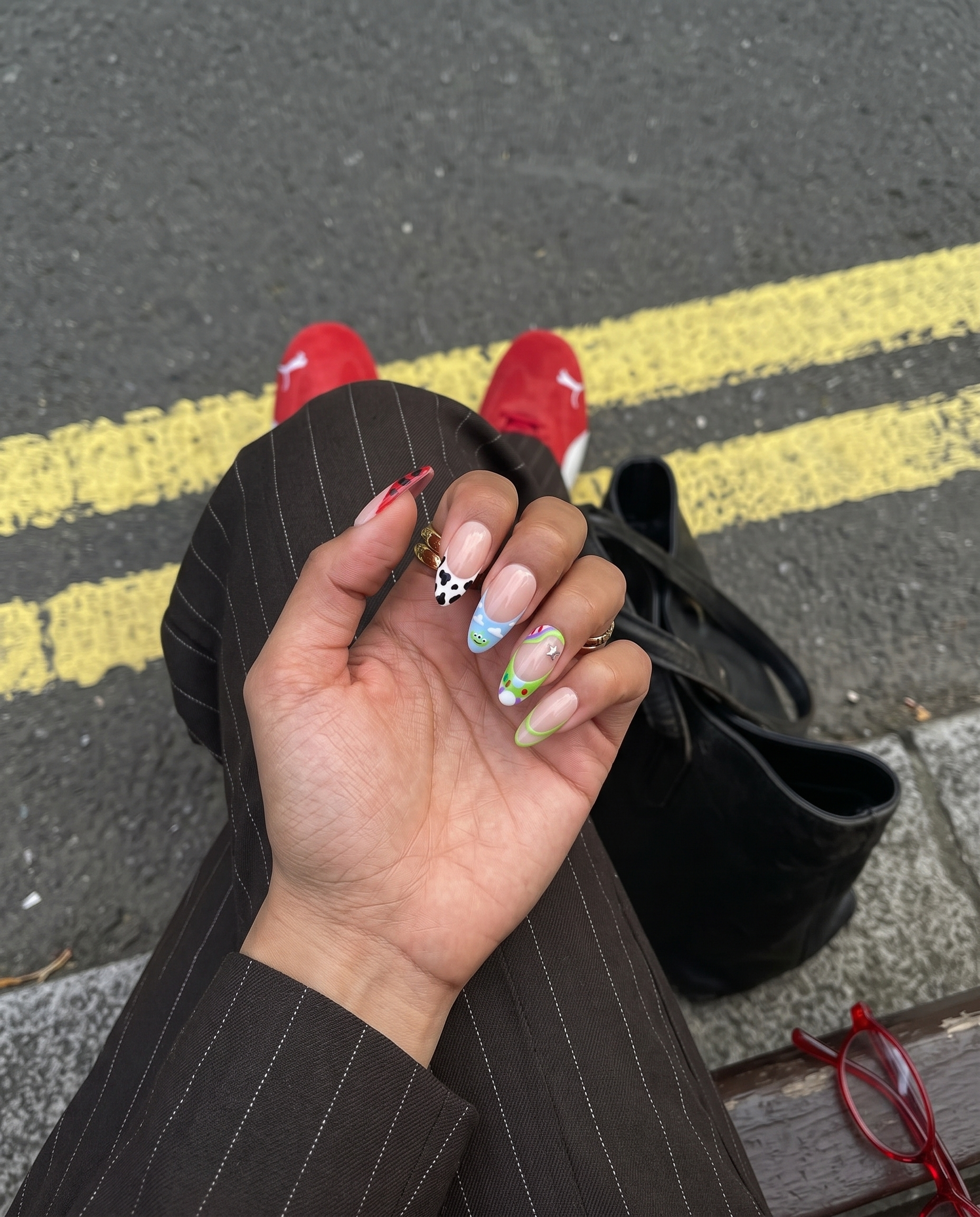 Toy Story inspired press-on nails with character themed French tips and star charms.