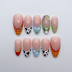 Toy Story inspired press-on nails with character themed French tips and star charms.